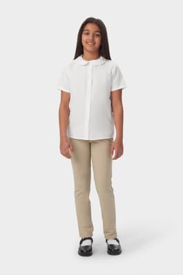 Girl wearing white French Toast girls&#39; short sleeve Peter Pan collar blouse, front view showing collar and button front.