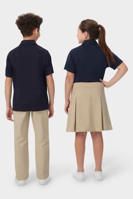 Back view of boy and girl wearing navy French Toast short sleeve performance polos, highlighting performance fabric.