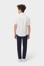 Back view of boy wearing a white French Toast short sleeve dress shirt in poplin, highlighting shirt fit and back design.