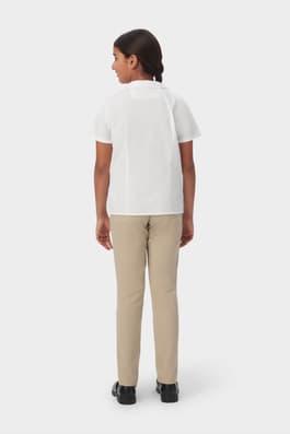 Back view of girl wearing white French Toast short sleeve Peter Pan collar blouse, showing back princess seams.