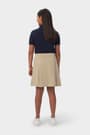 Back view of girl in khaki French Toast pull-on kick pleat performance skort, showing moisture wicking fabric.