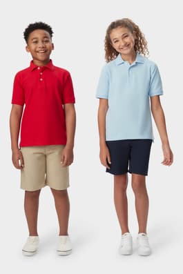 French toast pique polo shirts in red and blue worn by a boy and girl, front view showcasing a comfortable and co-ed style. of  Short Sleeve Pique Polo