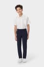 Boy wearing navy French Toast boys&#39; slim fit taper leg stretch performance pant, front view showing moisture wicking fabric. of  Boys' Slim Fit Taper Leg Stretch Performance Pant opens large image - 3 of 4