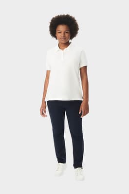 Young woman in French Toast short sleeve fitted stretch pique polo in white, front view showing tailored and feminine fit. of  Short Sleeve Fitted Stretch Pique Polo (Feminine Fit)