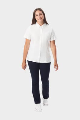Young woman wearing a white French Toast short sleeve fitted oxford blouse, front view showing buttons and length. of  Short Sleeve Fitted Oxford Shirt (Feminine Fit)