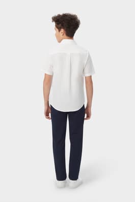 Back view of boy wearing a white French Toast short sleeve dress shirt in poplin, highlighting shirt fit and back design.