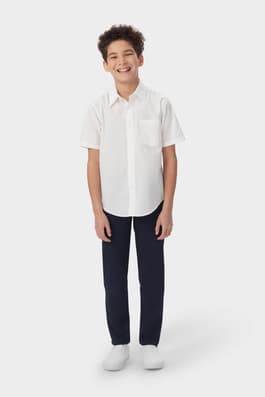 Boy wearing a white French Toast boys' short sleeve dress shirt in poplin, front view showcasing crisp, classic style.