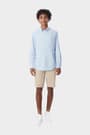 Young man wearing a blue French Toast long sleeve oxford shirt, front view showcasing detail and adult sizing.