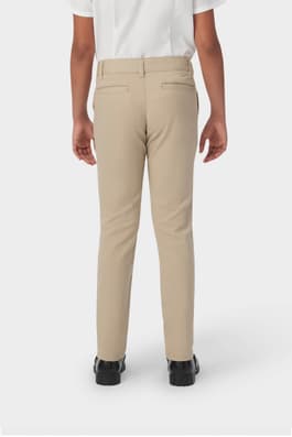 Back view of girl in khaki French Toast slim fit stretch twill pant, showing waistband and stretch twill fabric. of  Girls' Slim Fit Stretch Twill Pant