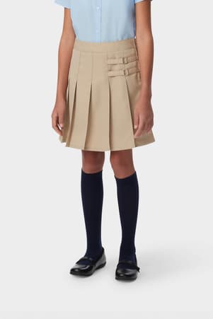 Front view of girl in khaki French Toast pleated two-tab skort, showing front knit pleats and classic tab detail styling.