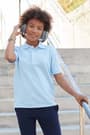 Girl with headphones in blue pique polo of  Short Sleeve Piqué Polo opens large image - 3 of 4
