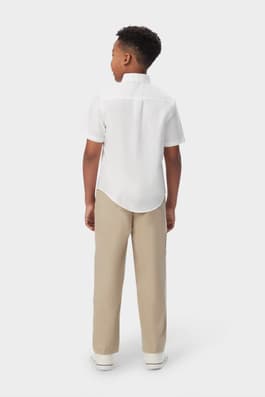 Back view of boy wearing a white French Toast short sleeve oxford shirt, showing hem designed for tucking.