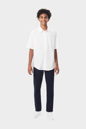 Young man wearing a white French Toast short sleeve dress shirt in poplin, front view showcasing classic, clean style.