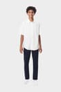 Young man wearing a white French Toast short sleeve dress shirt in poplin, front view showcasing classic, clean style.