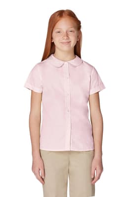 Girl wearing white French Toast girls&#39; short sleeve Peter Pan collar blouse, front view showing collar and button front.