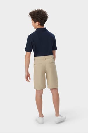 Boy wearing khaki French Toast flat front stretch performance short, back view showing waistband and pockets. of  Boys' Flat Front Stretch Performance Short