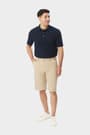 Man wearing khaki French Toast flat front stretch performance short, front view showing side pockets and above the knee length. of  Boys' Flat Front Stretch Performance Short opens large image - 5 of 5