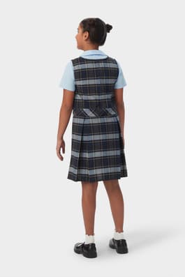 Back view of girl in blue gold plaid French Toast plaid box pleat jumper, showing back pleats and back zip.