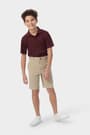 Boy wearing khaki French Toast boys&#39; flat front stretch twill short, side pockets and above the knee length, front view. of  Boys' Flat Front Stretch Twill Short opens large image - 3 of 5