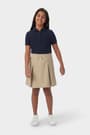 Girl wearing khaki French Toast pull-on kick pleat performance skort, front view showing at the knee length and elastic waistband.