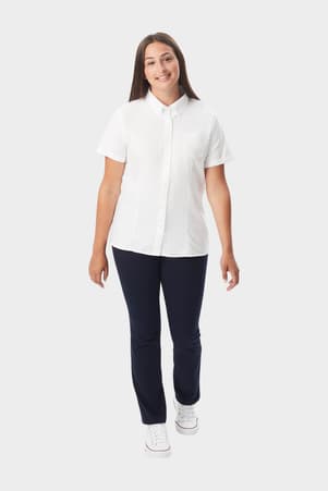 Young woman wearing a white French Toast short sleeve fitted oxford blouse, front view showing buttons and length. of  Short Sleeve Fitted Oxford Shirt (Feminine Fit)