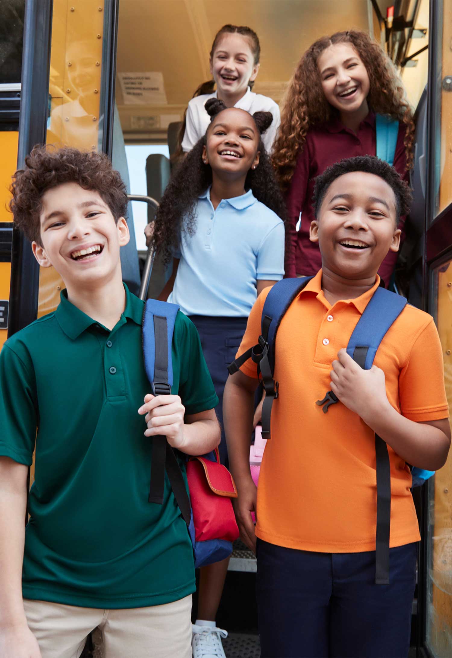 Children coming off school bus in French Toast polos