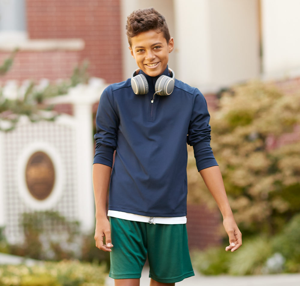 boy wearing shorts and performance quarter zip pullover