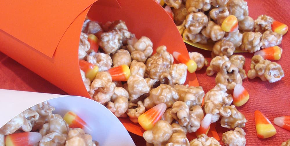 Cone shaped paper containing caramel corn and candy corn