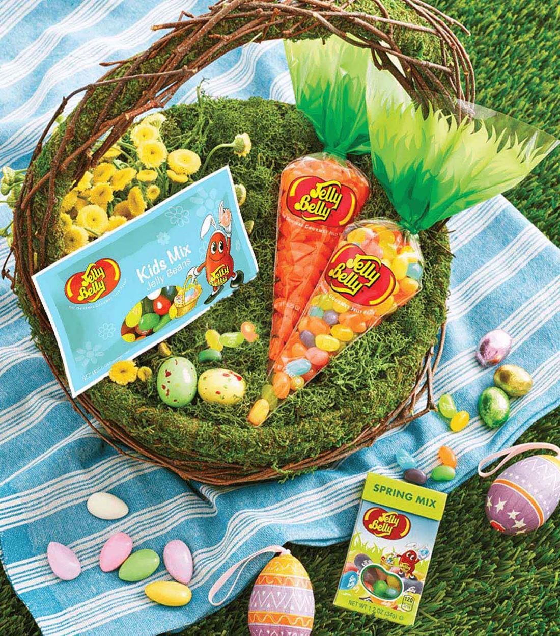Easter Basket filled with Jelly Belly Carrot Bags, Easter Kids Mix 1 oz Bags, and Speckled Chocolate Malted Eggs, on a blue blanket in the grass