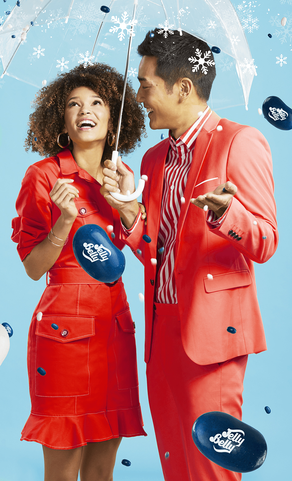 Young man and woman under umbrella catching Jelly Belly snoflakes