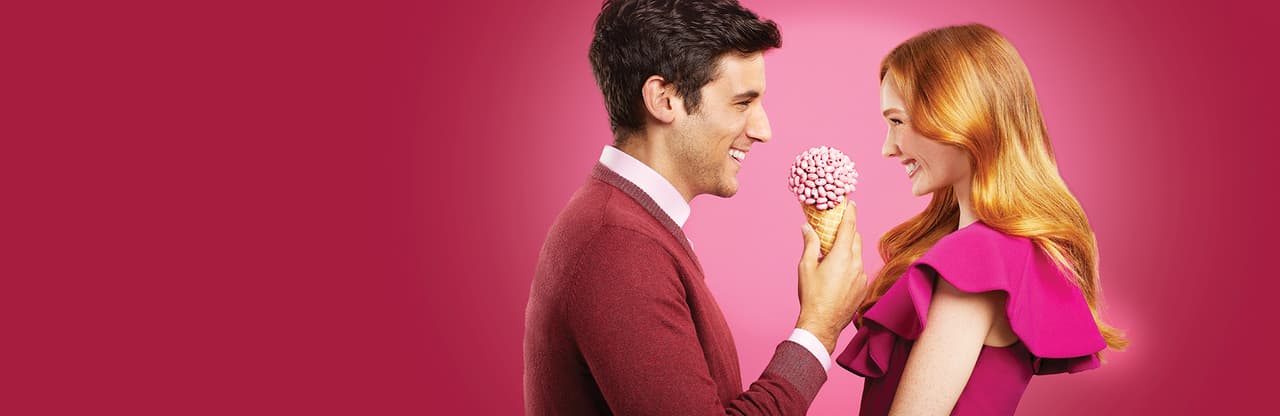 Young man offering young woman ice cream cone topped with jelly belly jelly beans