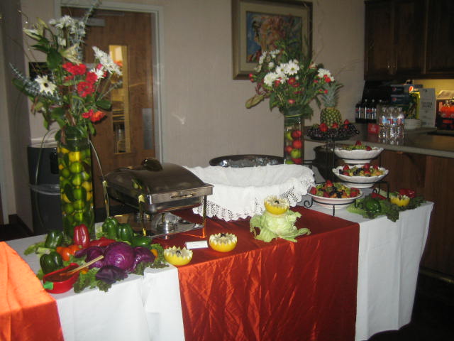 table set up with fruit salads in front of an island bar in a banquet room