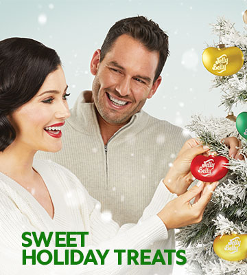 Man and woman decorating a Christmas Tree with jelly bean shaped ornaments, with text Sweet Holiday Treats