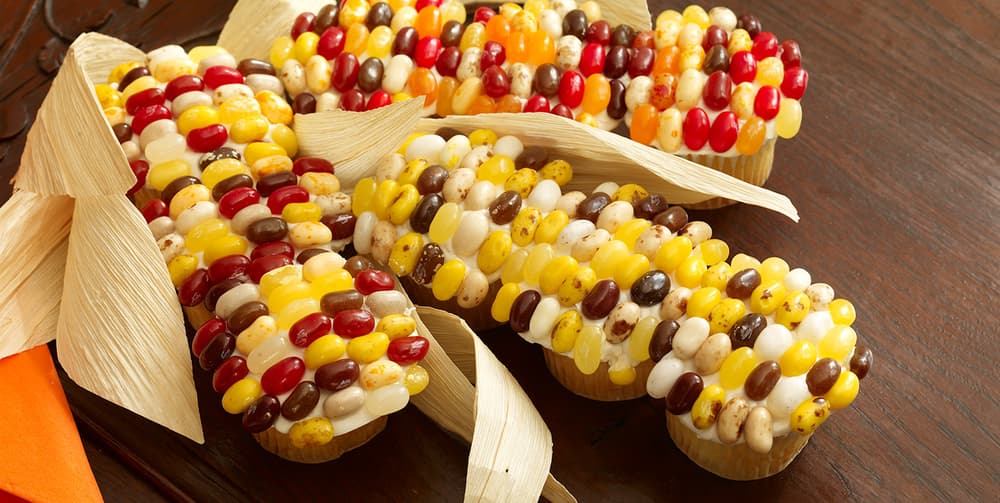 cupcakes with jelly beans on top that look like harvest corn with leaves on the side